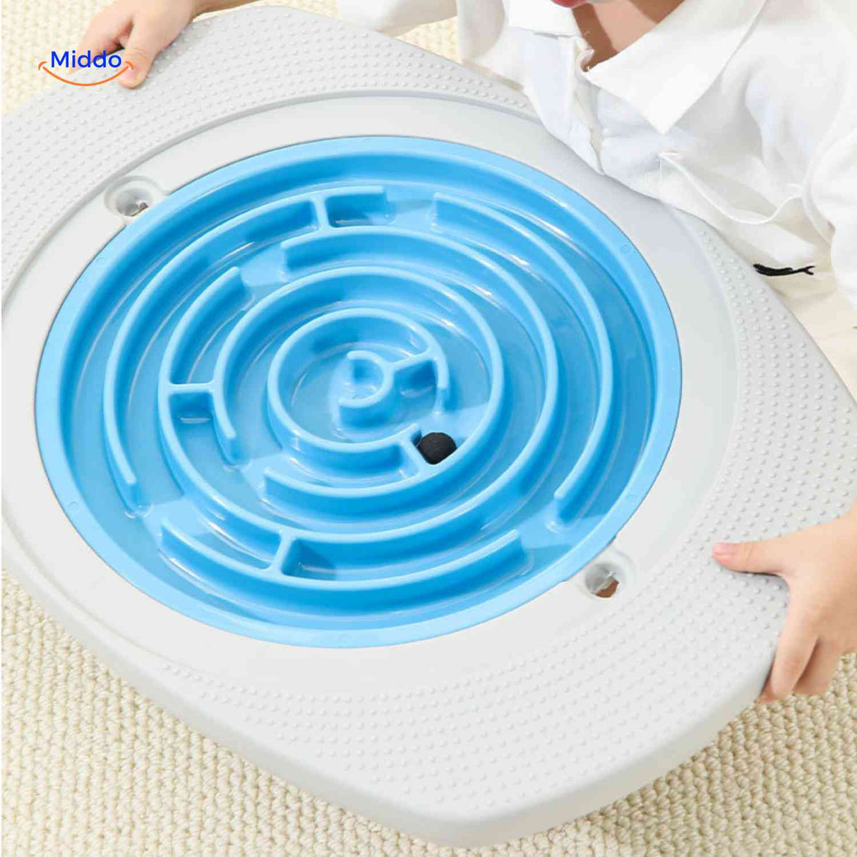 Child playing with blue spiral maze disc on balance board game