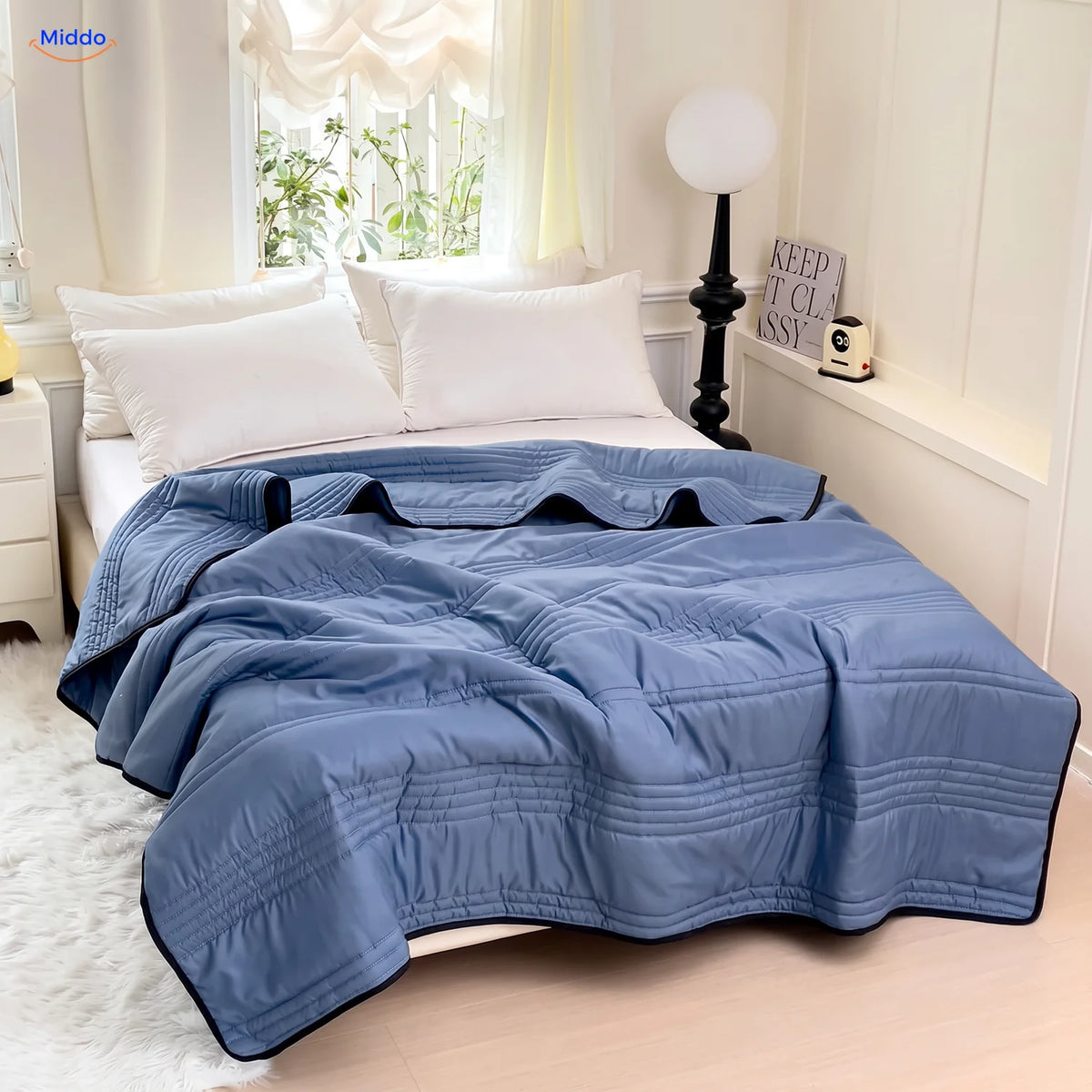 Coolwave cooling blanket in dark blue on a made bed