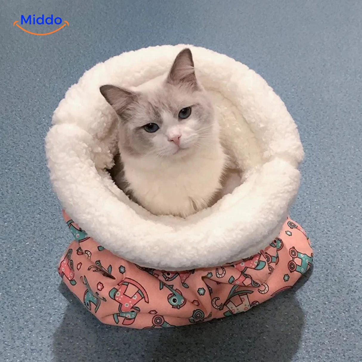 Cozy cat bed in pink rocking horse pattern with cat inside.