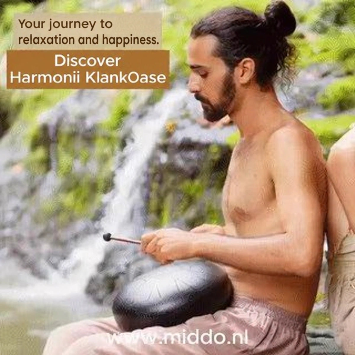 Man playing a Harmonii steel tongue drum beside a waterfall.