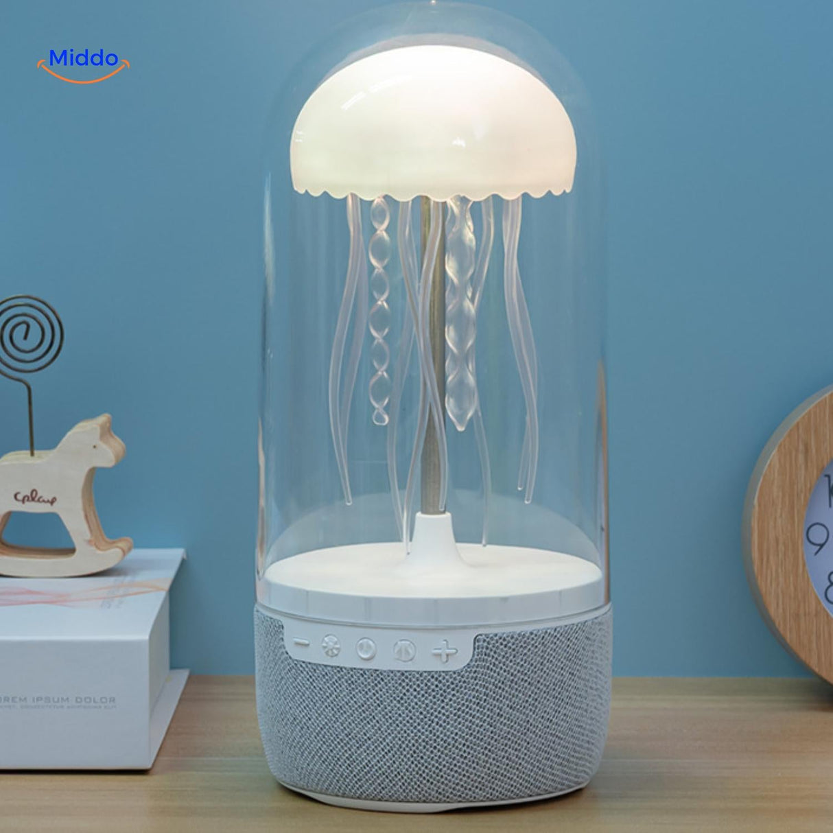 JellyGlow mini speaker with warm ambient lighting illuminating a home desk setup.