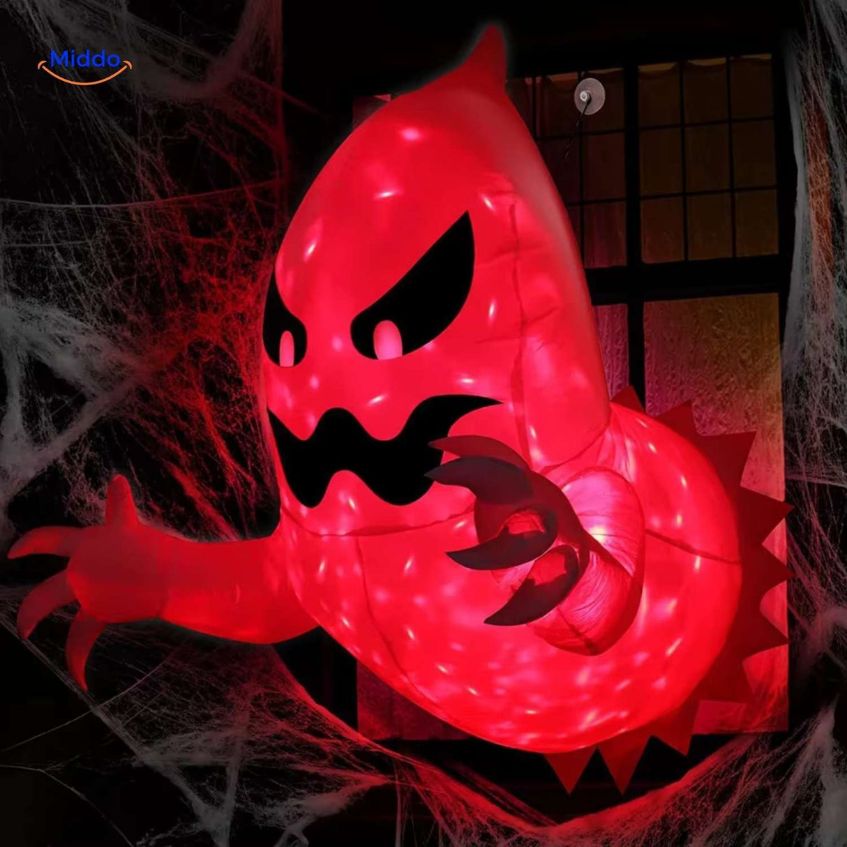 Spooky red-lit monster inflatable peeking through window with atmospheric lighting.