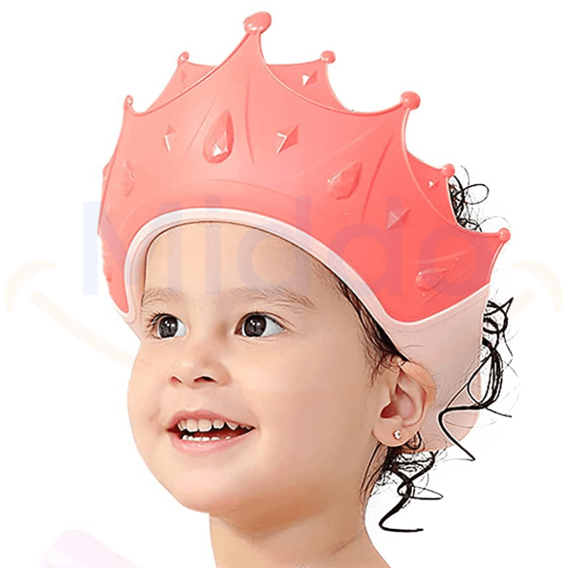 Young child wearing a pink ShampooCrown shower cap during bath time.