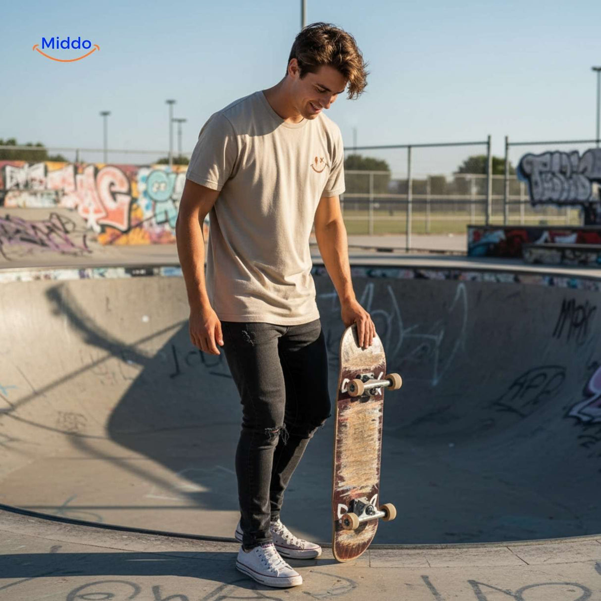 Breathable cotton t-shirt with smiley print worn at skatepark by man with skateboard.