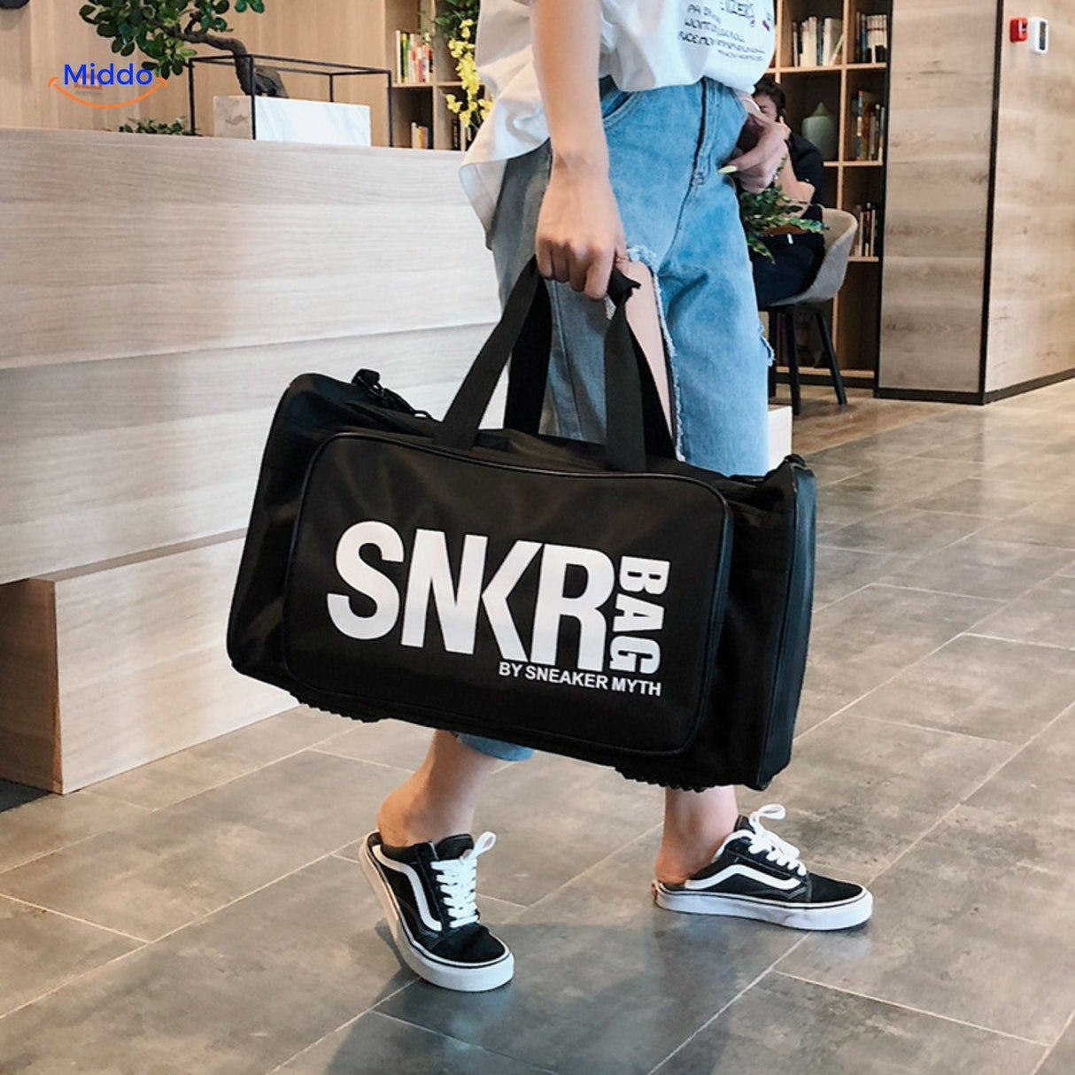 User wearing gloves while carrying SNKRPro sports travel bag.