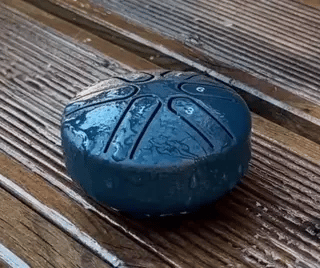 Steel tongue drum tested in rain demonstrating weather-resistant design.