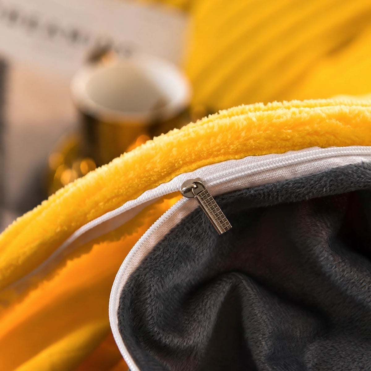 Close-up of the zipper closure on a yellow and gray velvet fleece duvet cover.