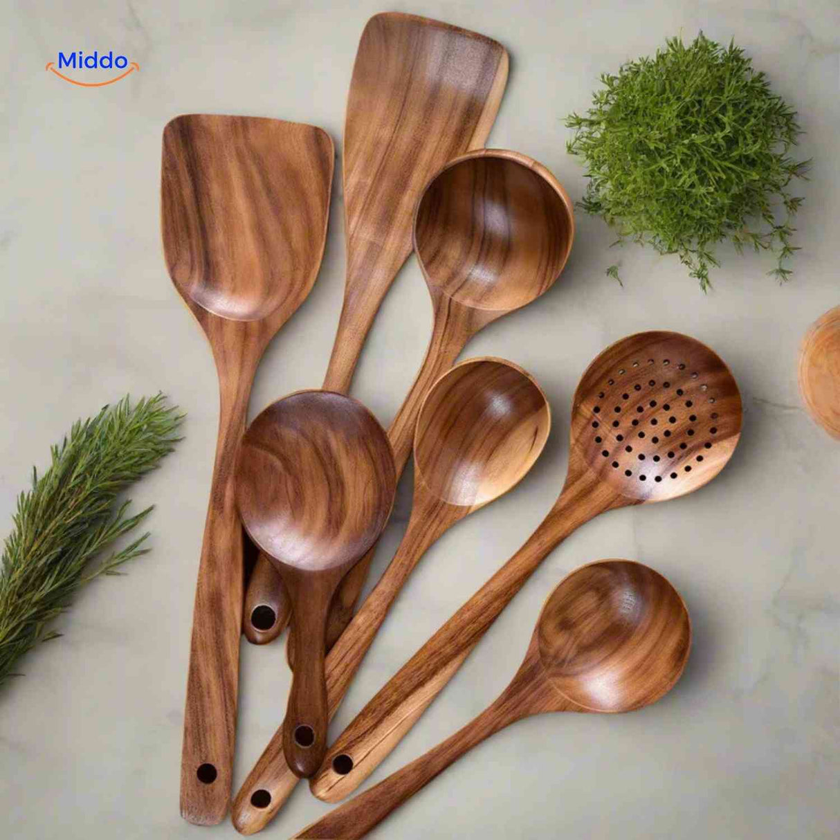 Wooden cooking spoons and spatulas displayed on kitchen table showing full set variety.