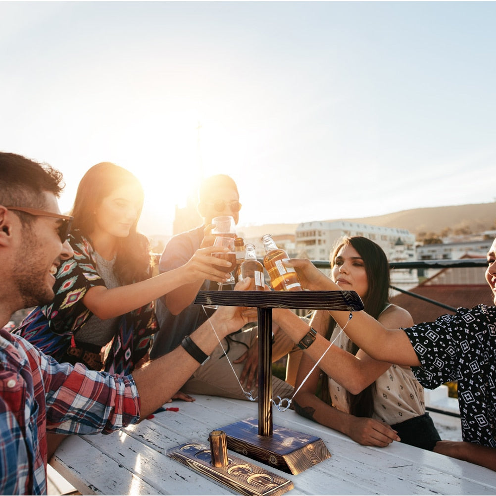 Group celebrating with wooden ring toss game outdoors in backyard.