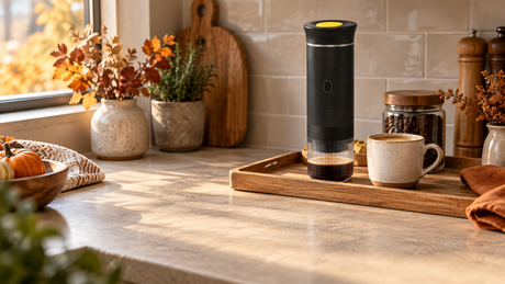 Black BrewMaster on a small tray beside a cup with clear kitchen counter space nearby
