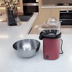 Fully automatic electric popcorn maker in operation showing ease of use.