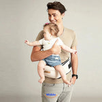 Father wearing baby hip carrier while holding toddler securely on his hip.