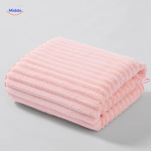 Light pink textured bath towel with waffle weave design.