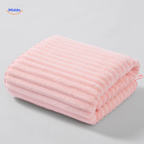 Light pink textured bath towel with waffle weave design.