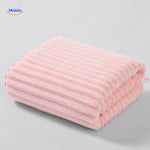 Light pink textured bath towel with waffle weave design.