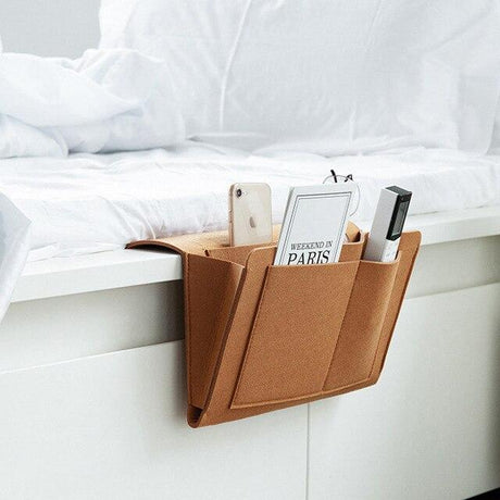 BedCaddy bedside storage organizer in premium brown leather construction.