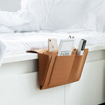 BedCaddy bedside storage organizer in premium brown leather construction.
