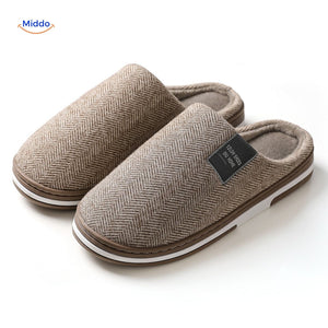 Close-up detail of beige cotton slippers on white background.