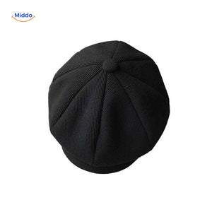 Black rib knit newsboy cap combining vintage design with soft comfort.