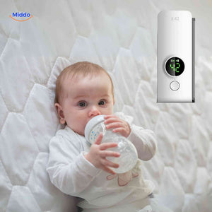 Baby comfortably drinking warm milk thanks to a portable cordless bottle warmer