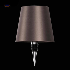 Brown rechargeable dimmable bottle lamp creating warm ambient light.