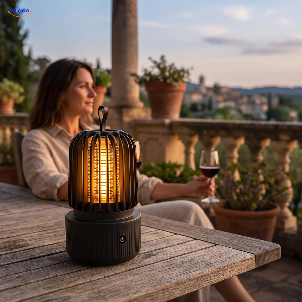 BuzzAway mosquito lamp in warm light mode on a terrace table at dusk