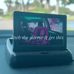Baby car monitor mounted on dashboard with live backseat view.