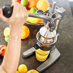Citripress juicer next to a glass of freshly squeezed citrus juice.