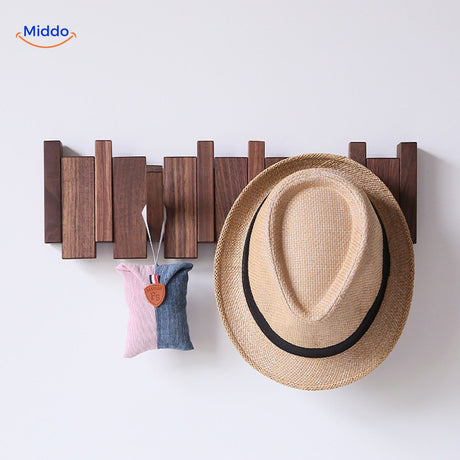 Piano coat rack showcasing hats and accessories on its foldable wooden hooks.