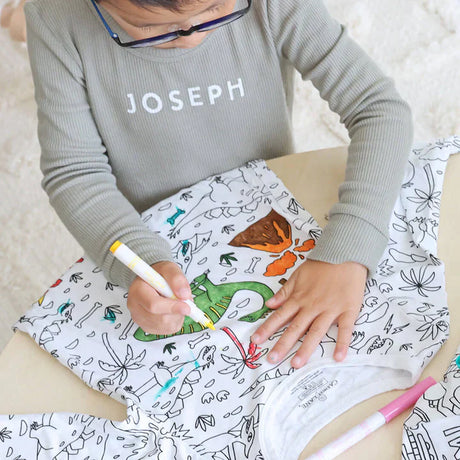 Dinosaur-theme color-your-own pajama being colored by child.