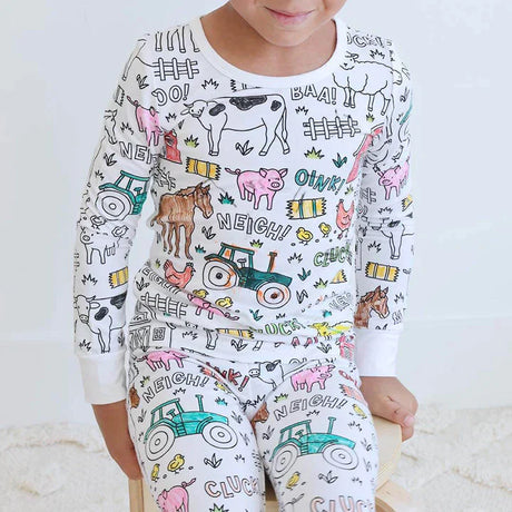 Farm-design color-your-own pajama with child actively coloring details.