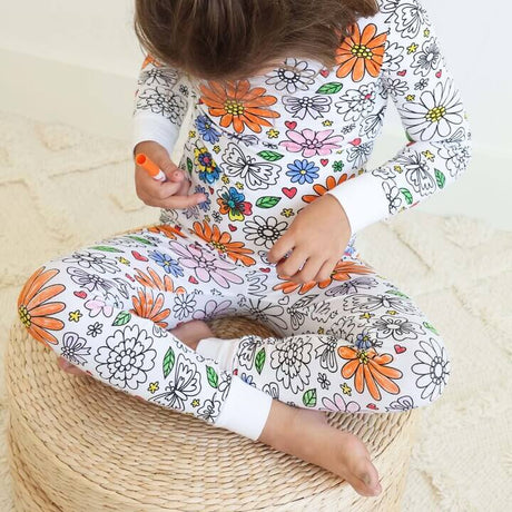 Floral-theme color-your-own pajama worn by child while coloring.