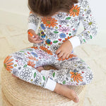 Floral-theme color-your-own pajama worn by child while coloring.