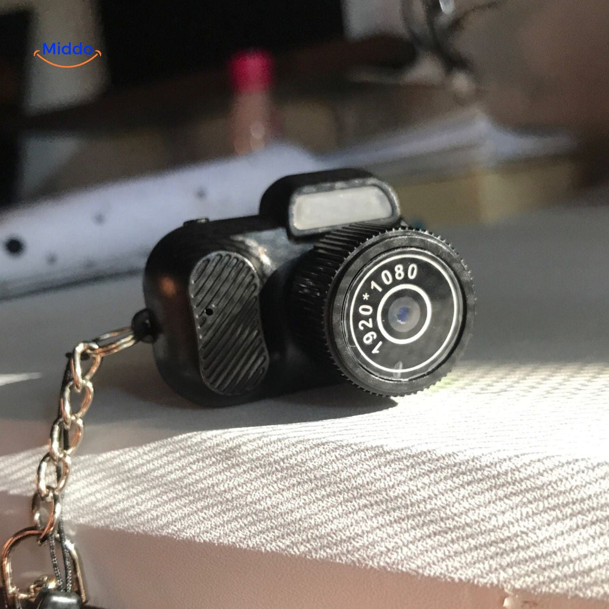 Compact HD mini camera sitting on desk with macro detail view