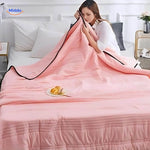 Cooling blanket in light pink showcasing breathable lightweight summer design.