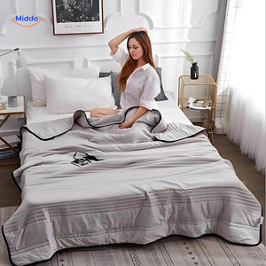 Lightweight cooling blanket draped on bed showing breathable comfort and style.
