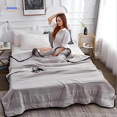 Lightweight cooling blanket draped on bed showing breathable comfort and style.