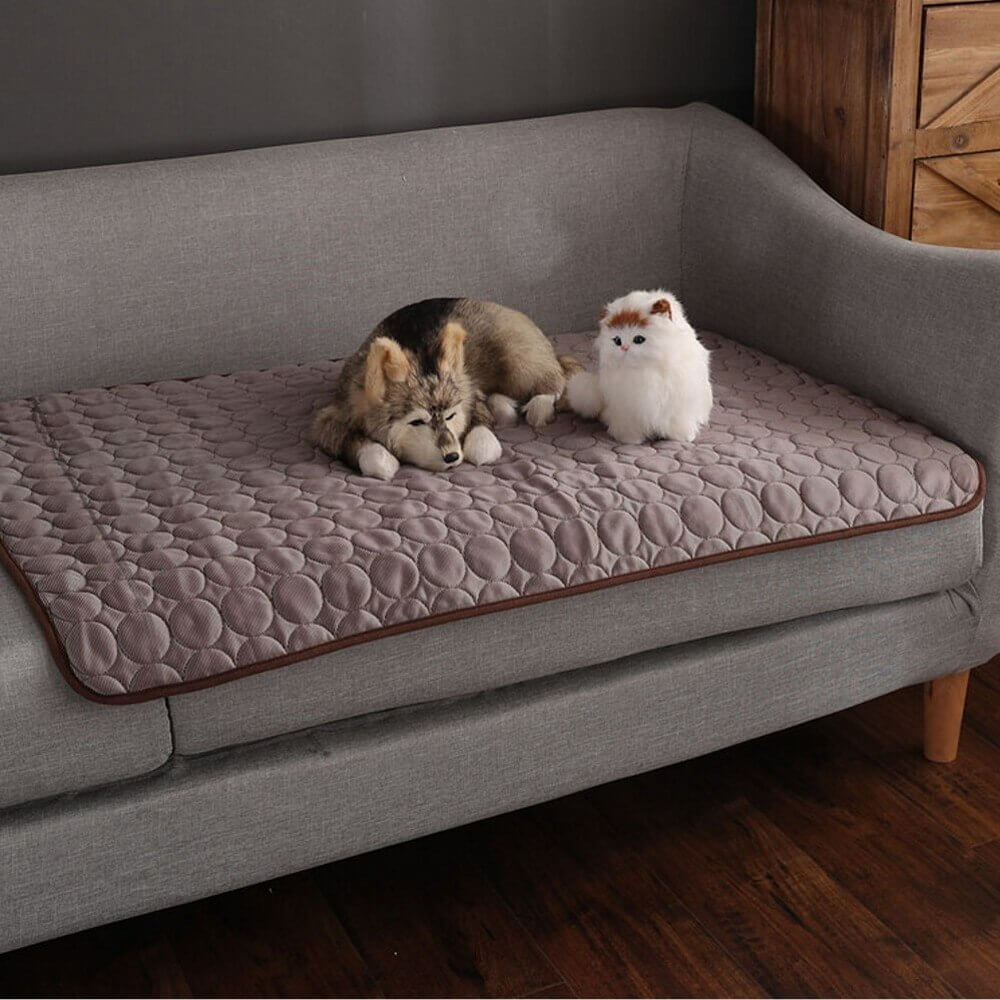 Brown cooling mat draped on couch for convenient pet access.