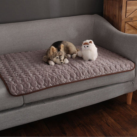 Brown cooling mat draped on couch for convenient pet access.