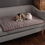 Brown cooling mat draped on couch for convenient pet access.