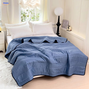Coolwave cooling blanket in dark blue on a made bed