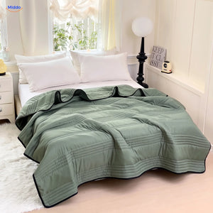 Coolwave cooling blanket in military green on a made bed