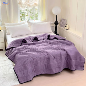 Coolwave cooling blanket in purple on a made bed