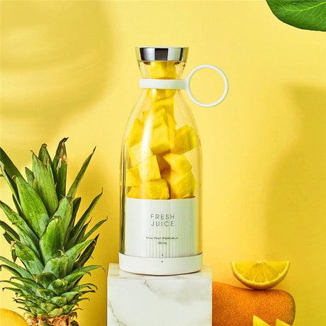 Close-up of cordless blender with fresh pineapple and mixed tropical fruits.