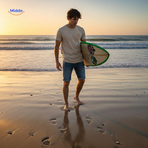 Soft cotton smiley t-shirt styled with surfboard by man at beach.