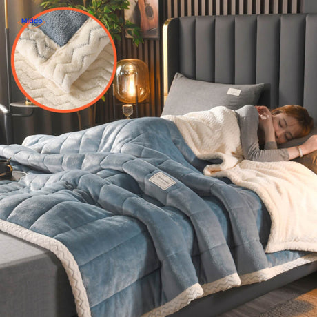 Light blue plush wool blanket folded neatly on bedding.