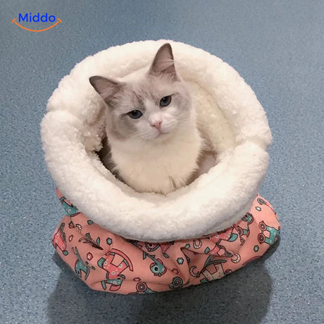 Cozy cat bed in pink rocking horse pattern with cat inside.