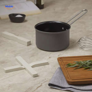 Cream-colored wooden trivet protecting countertop with hot cookware in use.