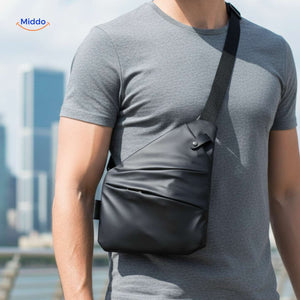 Unisex black Stratos crossbody bag worn over gray shirt during casual travel.