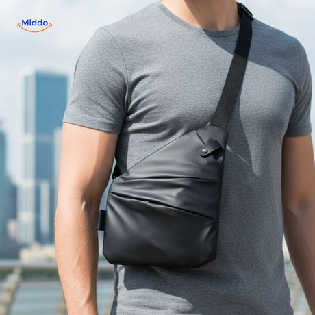 Unisex black Stratos crossbody bag worn over gray shirt during casual travel.